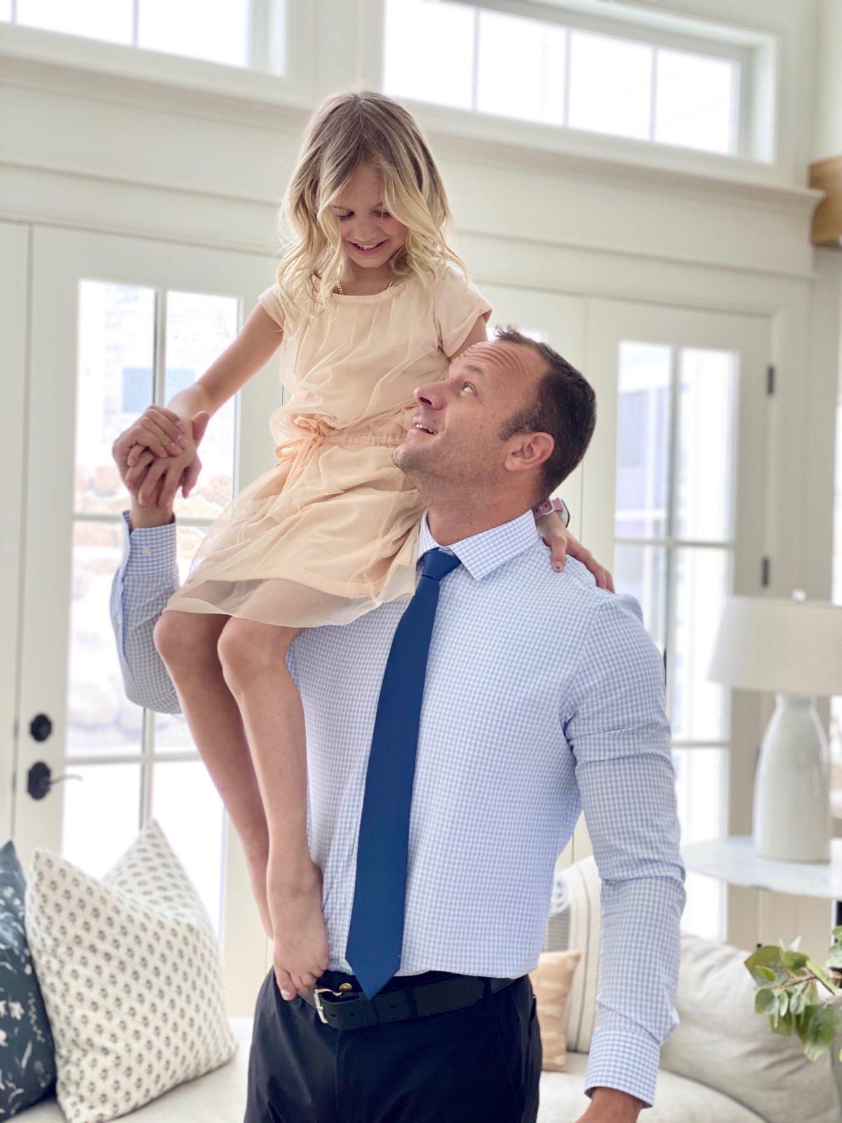 Dad dressed in Truwear men's business clothes with daughter riding on shoulder