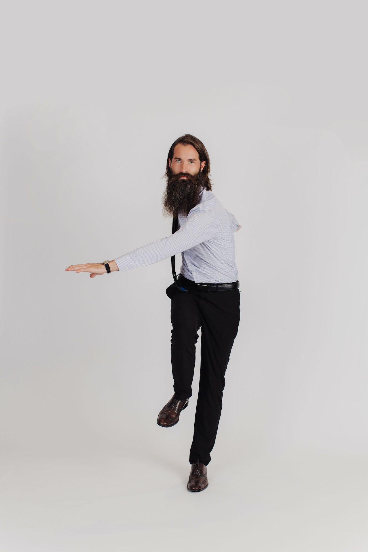 Bearded man stepping and twisting while wearing mens business clothes